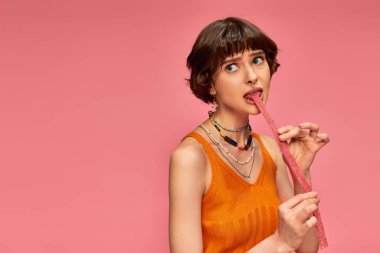 20 'li yaşlarda güzel bir kız, burun piercingli, beyaz dişli, tatlı ve ekşi çizgili, pembe çizgili.