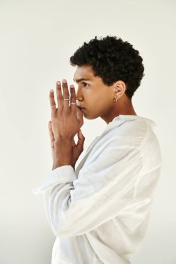 Zarif afro-amerikan şık keten elbiseli adam bej arka plana bakıyor.