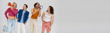 four jolly gay men in stylish outfits using megaphones and posing actively on gray backdrop, banner clipart