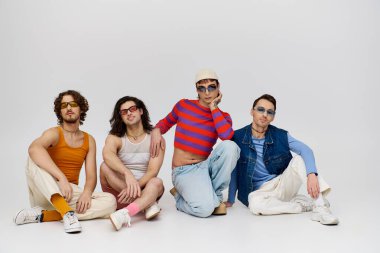 Dört çekici neşeli gay arkadaş şık güneş gözlükleriyle aktif olarak poz veriyorlar. Gurur ayı.
