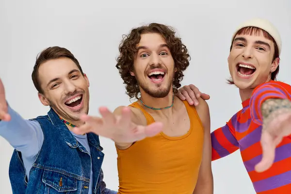 Vreugdevolle Jonge Gay Mannen Levendige Attires Samen Poseren Grijze Achtergrond — Stockfoto