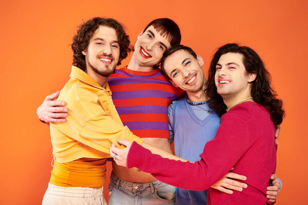 cheerful debonair gay men with makeup in vibrant attires posing actively together, pride month