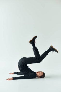 A young queer person showcases her strength and balance as she performs a handstand on a white background. clipart