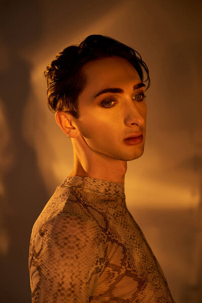 A young queer person in stylish attire stands introspectively before a mirror, exploring their identity and embracing self-love.