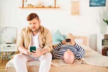 İki adam bir yatakta oturuyor, cep telefonu ekranına sarılmış..