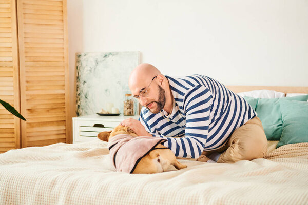 A man with glasses relaxing on a bed next to his French bulldog.