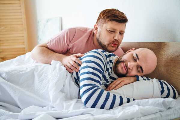 A couple of men peacefully lying next to each other in bed.