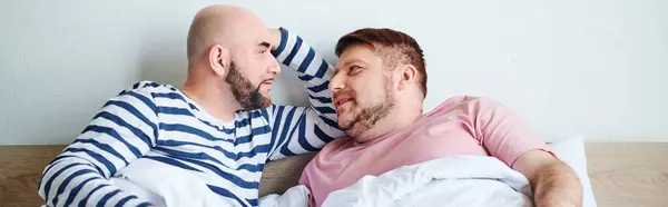 stock image Two men cuddle on a cozy bed, bonded by love and warmth.