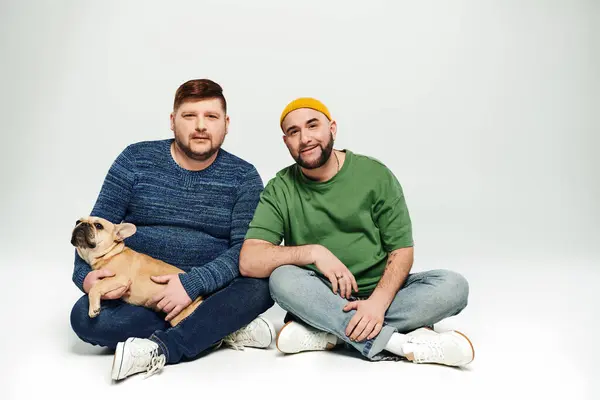 Two Men Sit Lovingly Holding French Bulldog — Stock Photo, Image