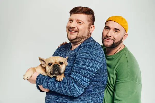 2人の男性は愛情を持って小さな犬を腕に抱き 一緒に時間を楽しんでいます — ストック写真