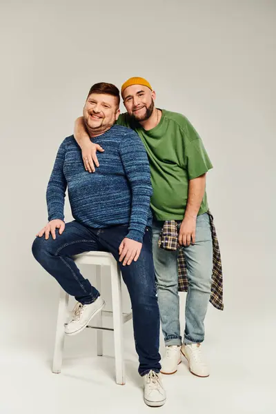 stock image Two men posing on a stool on white backdrop.