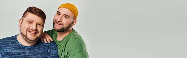 Двое мужчин стоят вместе и смотрят в камеру.