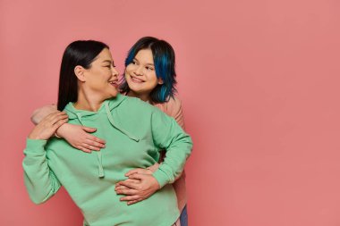 A serene moment captured as an Asian mother and her teenage daughter stand elegantly next to each other in a studio setting. clipart
