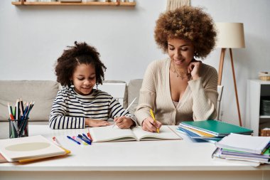 Afrika kökenli Amerikalı bir anne ve kızı bir masada oturup, ödevlerini yapmaya dalmış, özel bir anı paylaşıyorlar..
