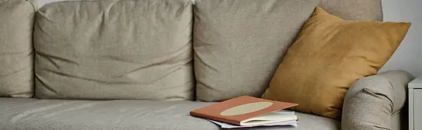 stock image A cozy couch with a book resting on top.