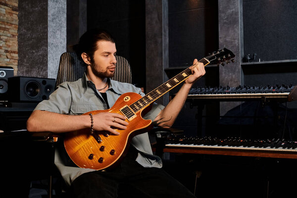 A skilled man playing an electric guitar in a recording studio as part of a music band rehearsal.