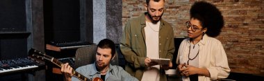 Profesyonel bir stüdyo ortamında müzik prova eden ve kaydeden çeşitli bir grup müzisyen..