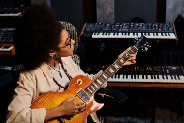 Müzik grubu provası için profesyonel bir kayıt stüdyosunda tutkulu gitar çalan yetenekli bir kadın..