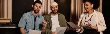 Kağıtlarla bir kayıt stüdyosunda oturan bir grup insan aktif olarak müzik grubunun prova oturumuna katıldılar..