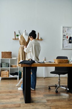 Yaratıcı genç bir kadın ekolojik ortamdaki bir masada kıyafet değiştiriyor..
