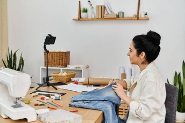 Gündelik giyinen kadın kıyafetlerini dikmek için dikiş makinesi kullanıyor..