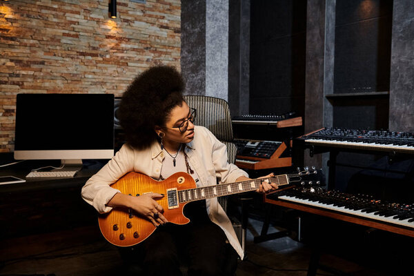 Талантливая женщина играет на электрогитаре в яркой студии звукозаписи во время репетиции музыкальной группы.