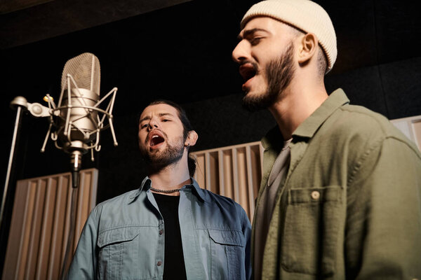 Two male musicians passionately sing into a microphone amidst the creative energy of a recording studio.