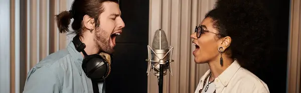 stock image A man and woman singing into a microphone with passion during a music band rehearsal in a recording studio.