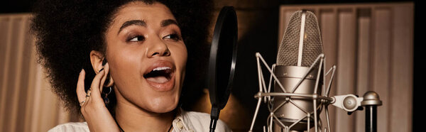 A talented woman passionately sings into a microphone during a music band rehearsal in a recording studio.