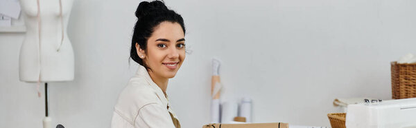 Молодая женщина поднимает одежду в комнате, улыбаясь в камеру.