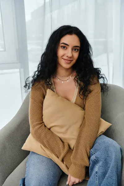 stock image Woman in chair, holding pillow.