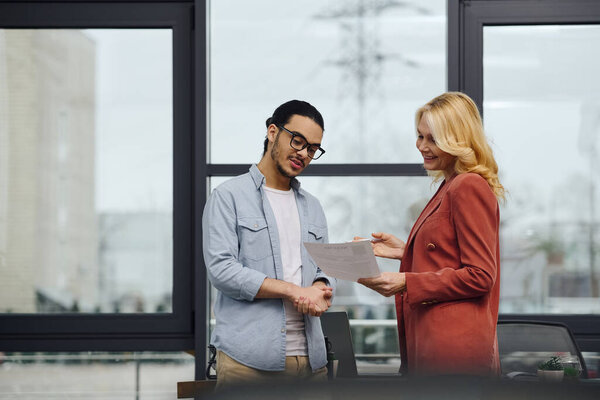 Man and woman shaking hands in office