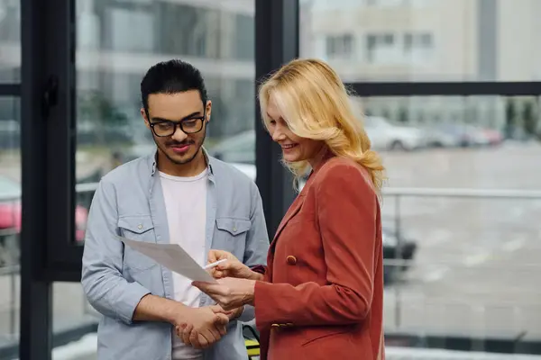 stock image Two people engage in a conversation outside an office building.