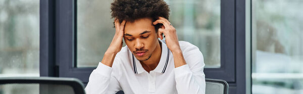 Человек в беде сидит за столом с головой в руках.