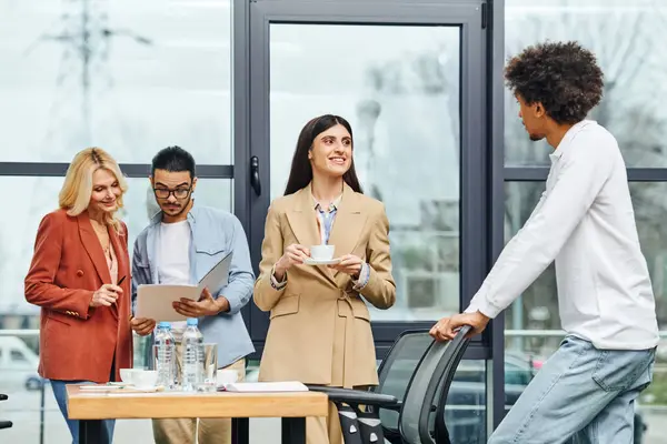 stock image Business people engage in animated discussions in a modern office setting.