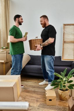 A gay couple exploring their new living room surrounded by packed boxes, beginning a new chapter together. clipart