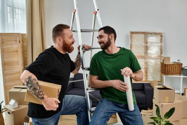 Birkaç adam, yeni bir eve taşınıyorlar, kutuların arasında kol kola duruyorlar, hayatlarında yeni bir başlangıcı simgeliyorlar..