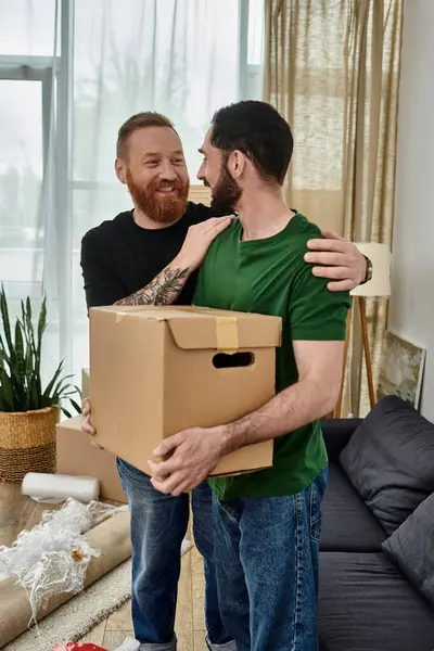 stock image Two men, a gay couple in love, share a quiet moment in their new living room amidst moving boxes.