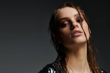 Genç bir kadın ıslak saçlarını güzel bir pozla gösteriyor..