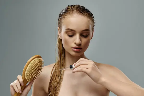 stock image Young woman with long wet hair using brush.