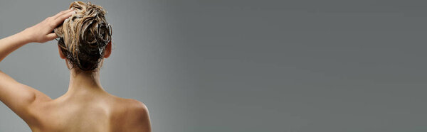 Молодая женщина показывает свою программу ухода за волосами с мокрыми волосами.