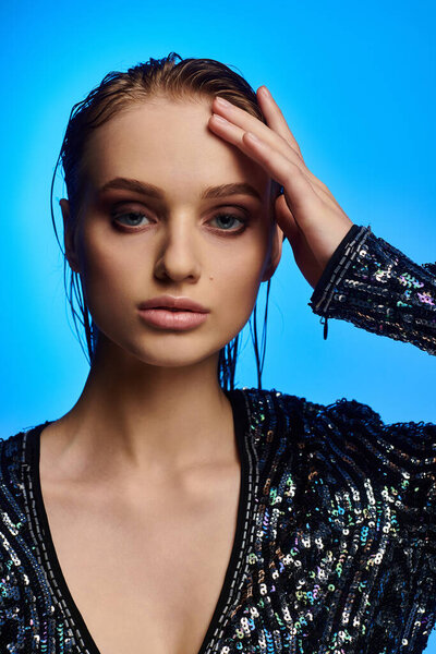 Молодая женщина в блёстках, ставящая позу.