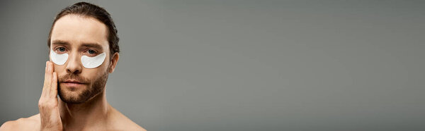 Мужчина без рубашки с бородой, с повязками на глазу, излучающий тайну и интригу в студии