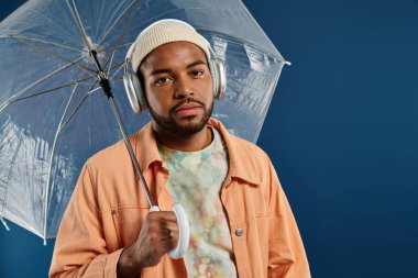 Şemsiyeli kulaklıklı şık bir adam..