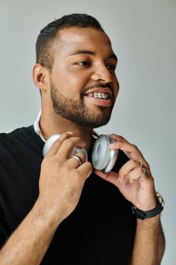 Siyah gömlekli, kulaklıklı Afro-Amerikalı bir adam..
