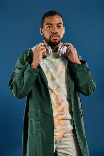 stock image A stylish African American man striking a pose against a vibrant blue backdrop.