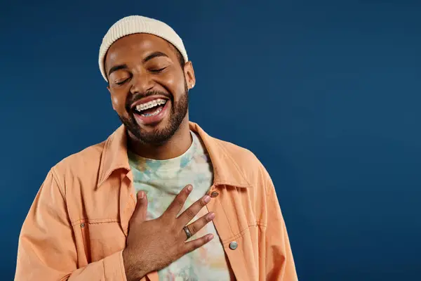 stock image Smiling man with closed eyes on colorful backdrop.