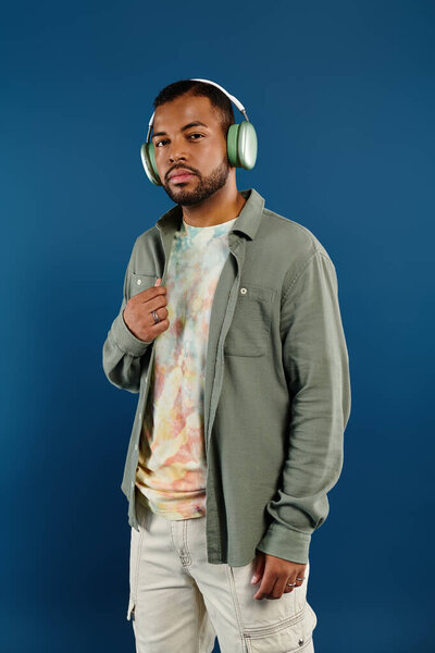 Афроамериканец в наушниках на ярком синем фоне.