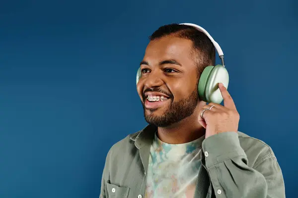 stock image Smiling African American man wearing headphones on colorful background.