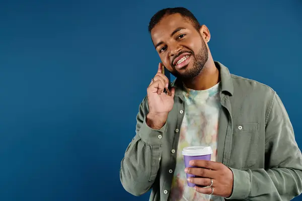 stock image Stylish African American man multitasking with coffee and phone.